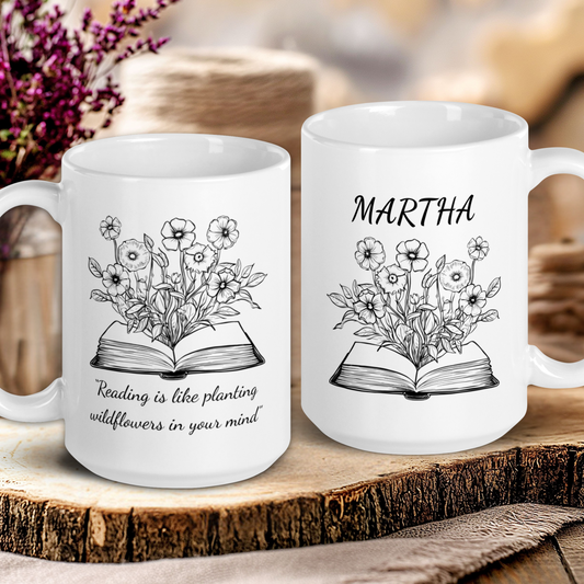 Two white mugs with floral and book designs on a wooden surface.