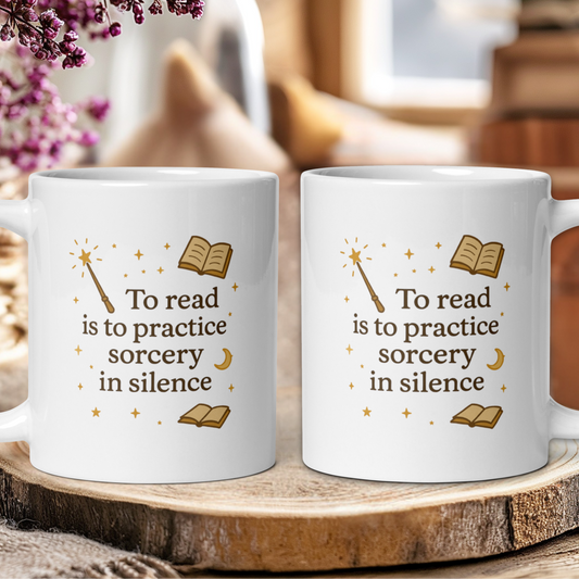 Two white mugs with a book-themed design and text on a wooden surface.