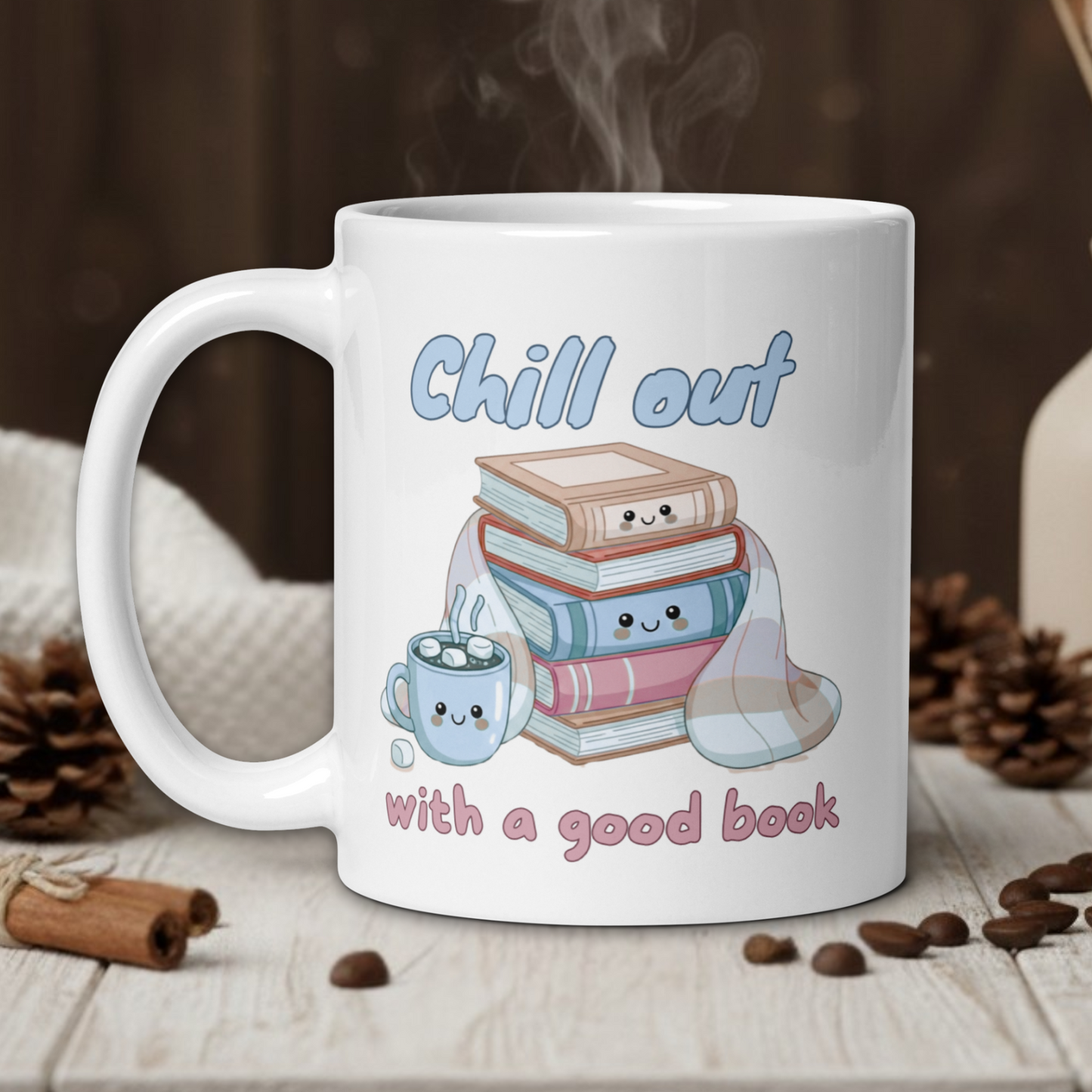 White mug with 'Chill out with a good book' design on a wooden table with coffee beans and a vase.
