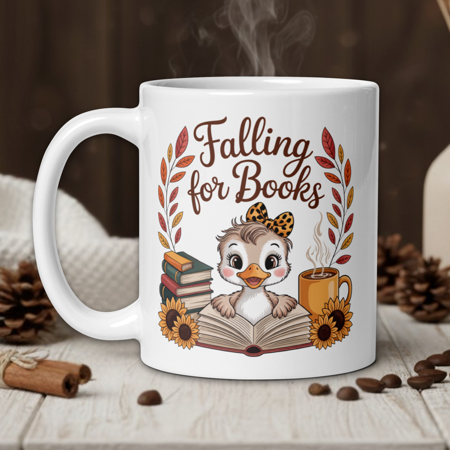 White mug with 'Falling for Books' design featuring a owl and books, on a wooden table with coffee beans and a vase in the background.