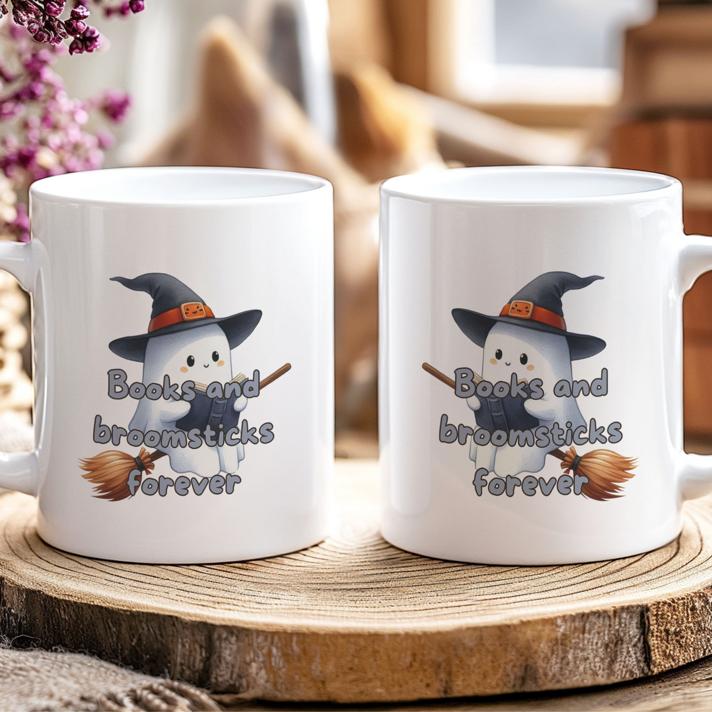 Two white mugs with a ghost design and text on a wooden coaster.