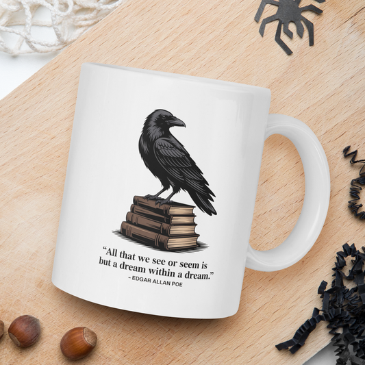 White mug with a crow design and quote on a wooden board with nuts and spider decorations.