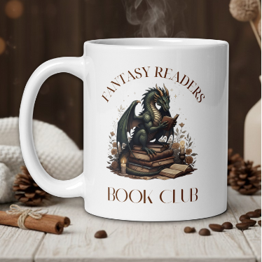 White mug with dragon design and 'Fantasy Readers Book Club' text on a wooden table with coffee beans and a vase.