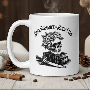 White mug with skull and roses design and 'Dark Romance Book Club' text on a wooden table with coffee beans and a vase.