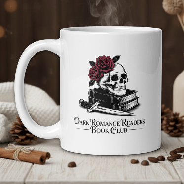White mug with skull and roses design on a wooden table with coffee beans and a vase in the background.