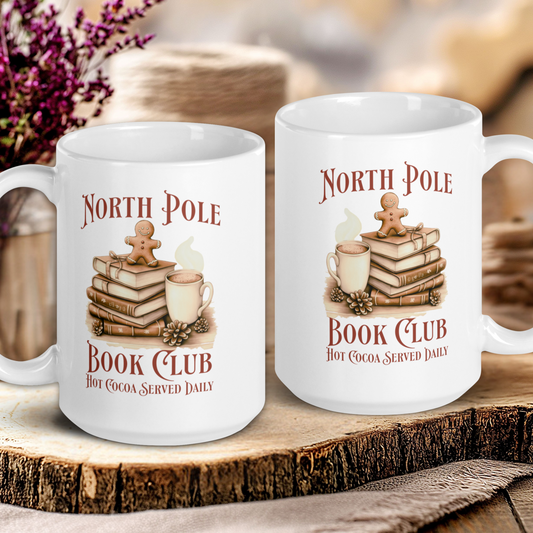 Two white mugs with 'North Pole Book Club' design on a wooden surface.
