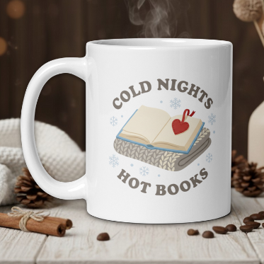 White mug with 'Cold Nights Hot Books' design on a wooden table with coffee beans and a vase.