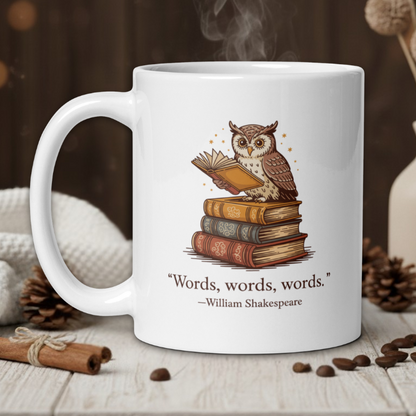White mug with owl and books design, featuring a quote by William Shakespeare, on a wooden table with coffee beans and a vase in the background.