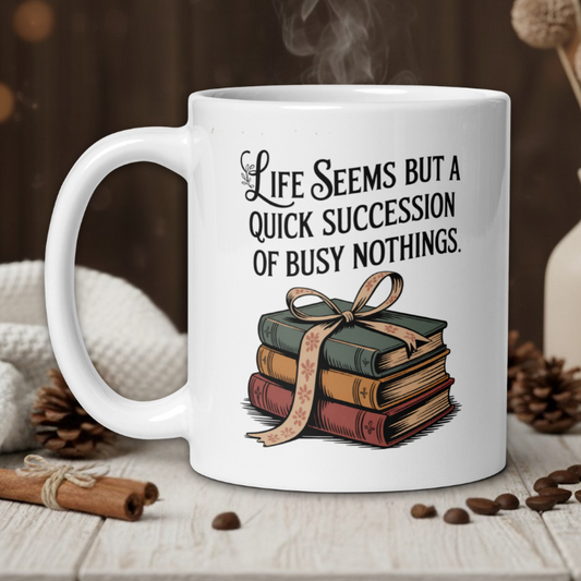 White mug with a book-themed design and text on a wooden table with coffee beans and a vase in the background.