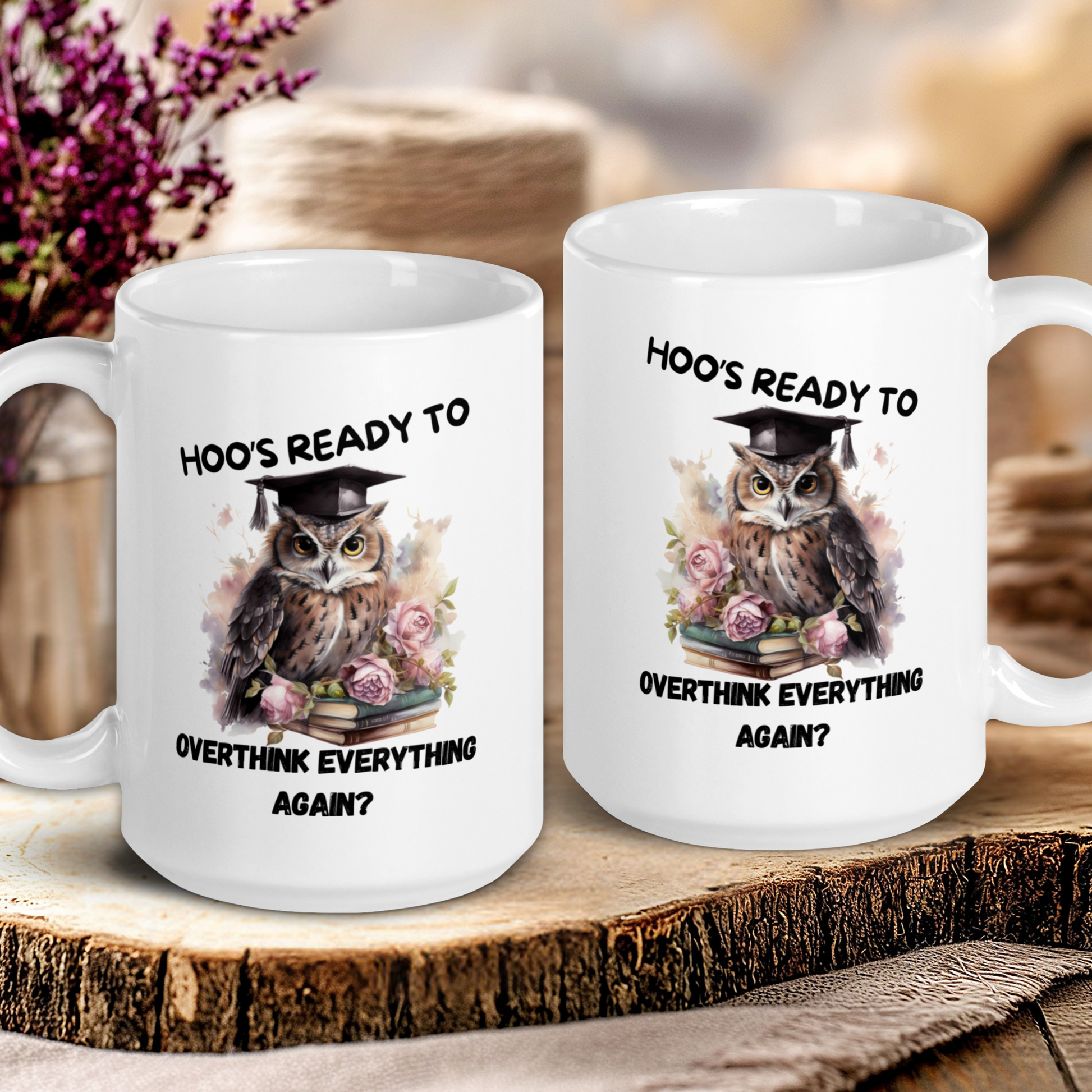Two white mugs with owl designs and text on a wooden surface.