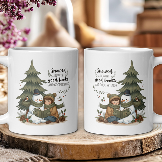 Two white mugs with winter-themed design featuring a snowman, child, and tree on a wooden surface.