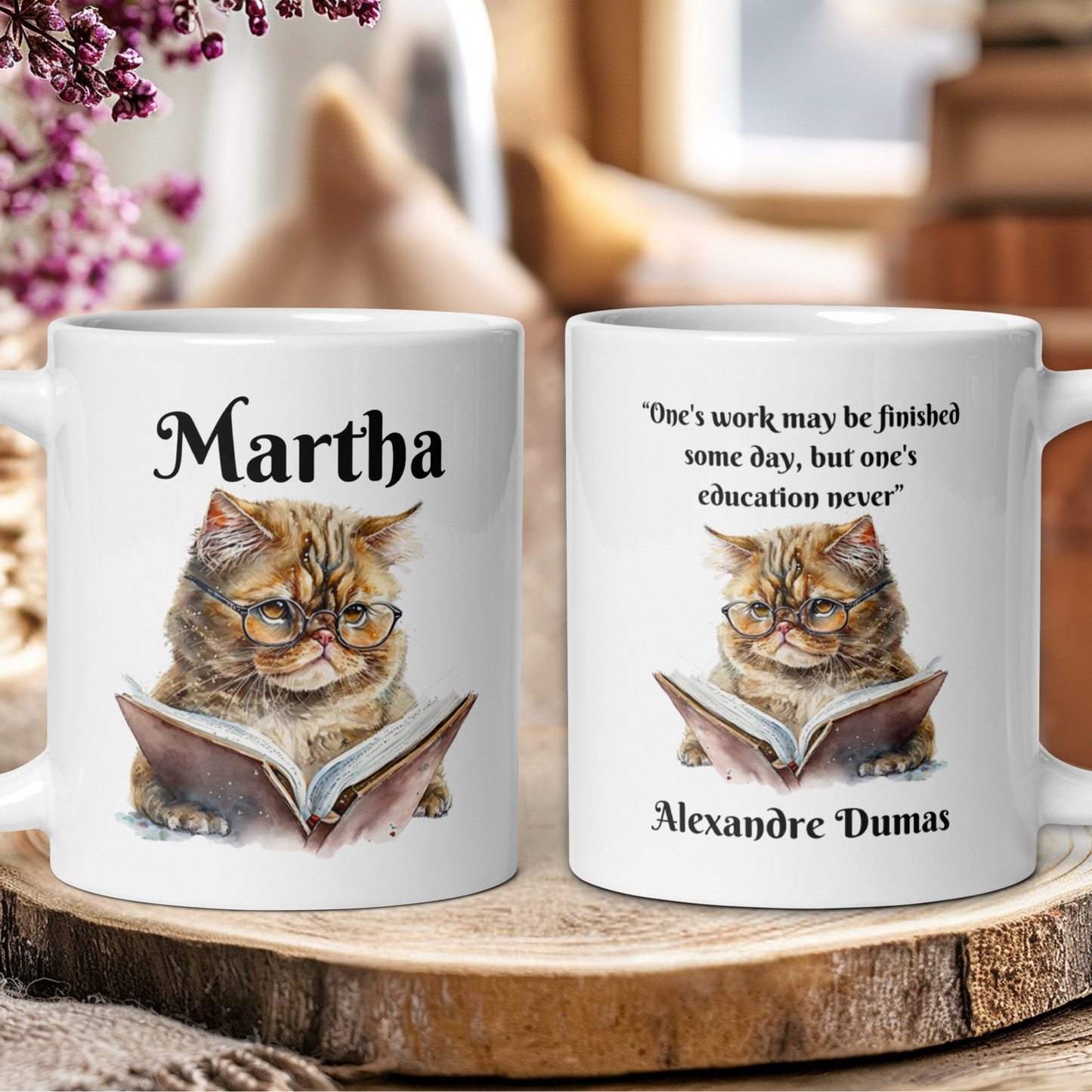 Two mugs with a cat illustration and text on a wooden surface.