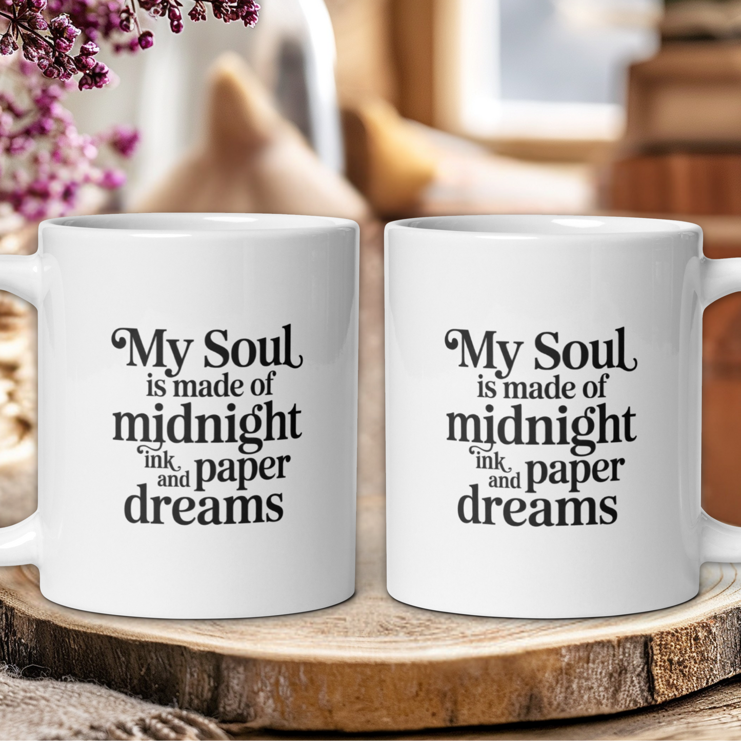 Two white mugs with a quote on a wooden surface with a blurred background