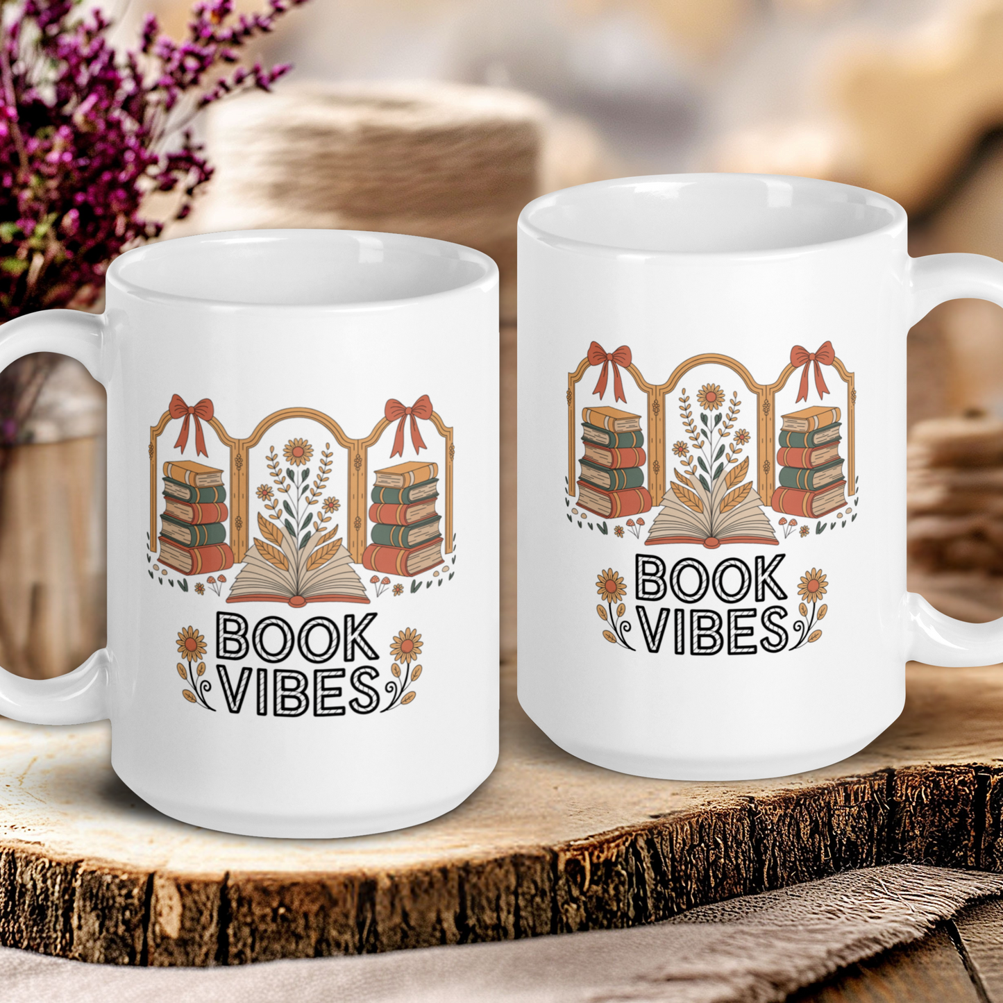 Two white mugs with 'Book Vibes' design on a wooden surface.