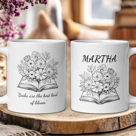 Two white mugs with floral designs and text on a wooden surface.