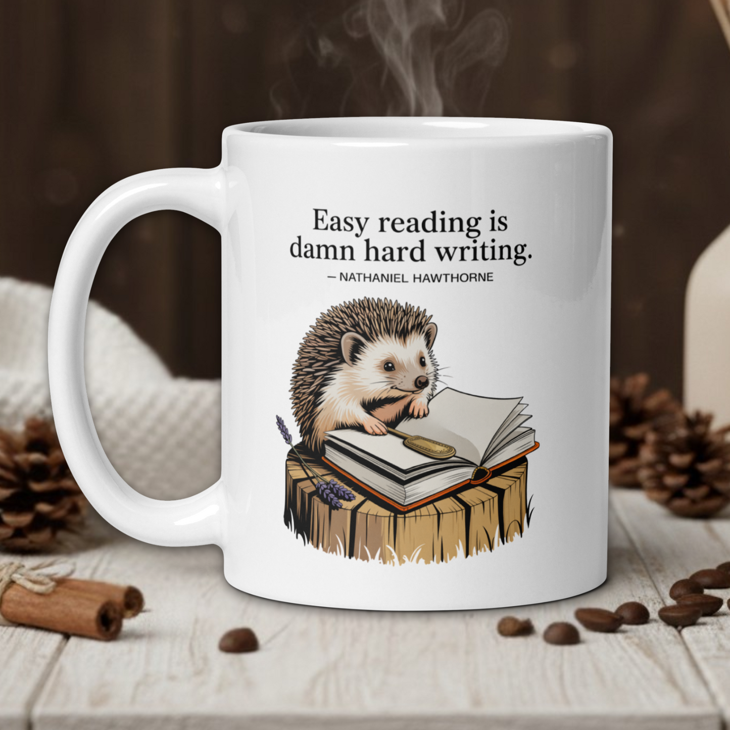 White mug with hedgehog illustration and quote on a wooden table with coffee beans and a vase in the background.