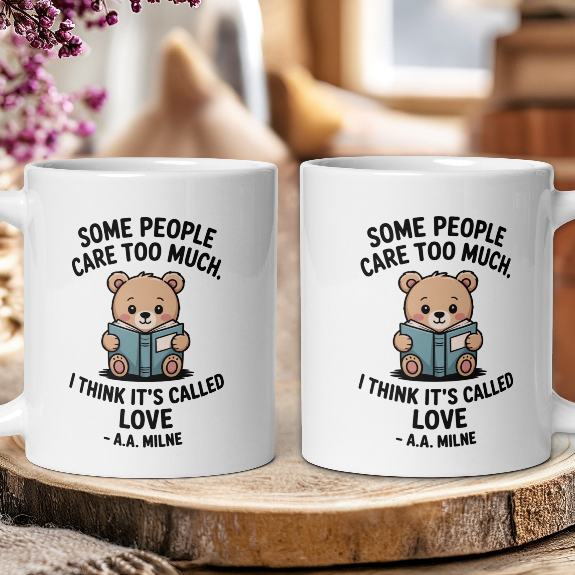 Two white mugs with a teddy bear illustration and text on a wooden surface.
