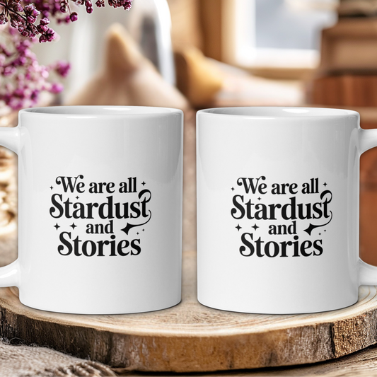 Two white mugs with text on a wooden surface, blurred background