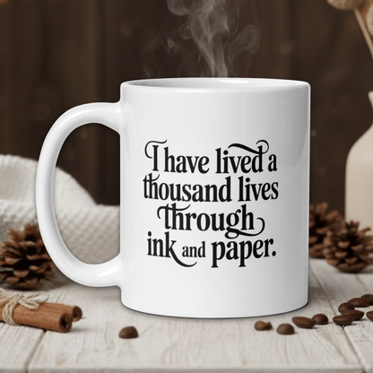 White mug with text on a wooden table with coffee beans and a vase in the background