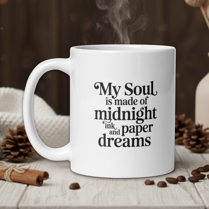 White mug with text on a wooden table with coffee beans and a vase in the background