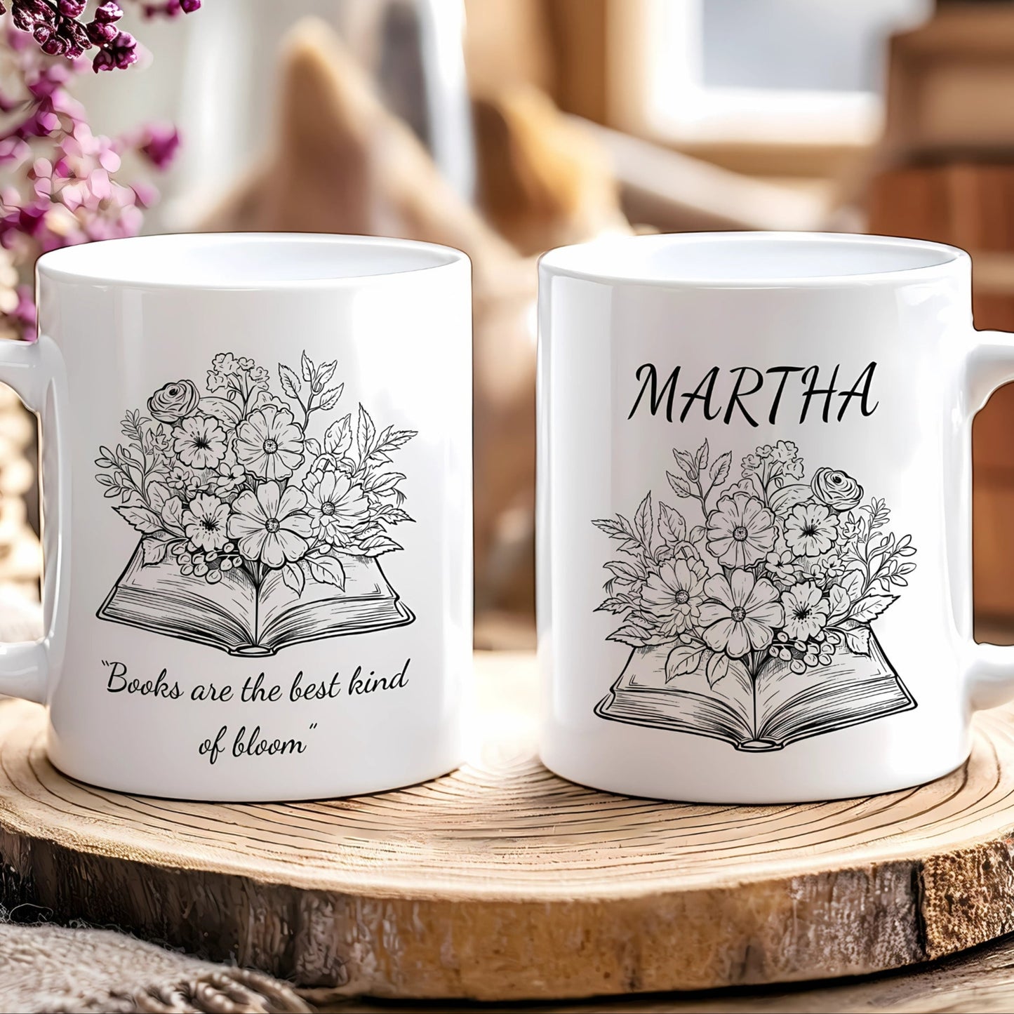 Two white mugs with floral and book design on a wooden surface