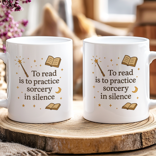 Two white mugs with decorative text on a wooden surface.
