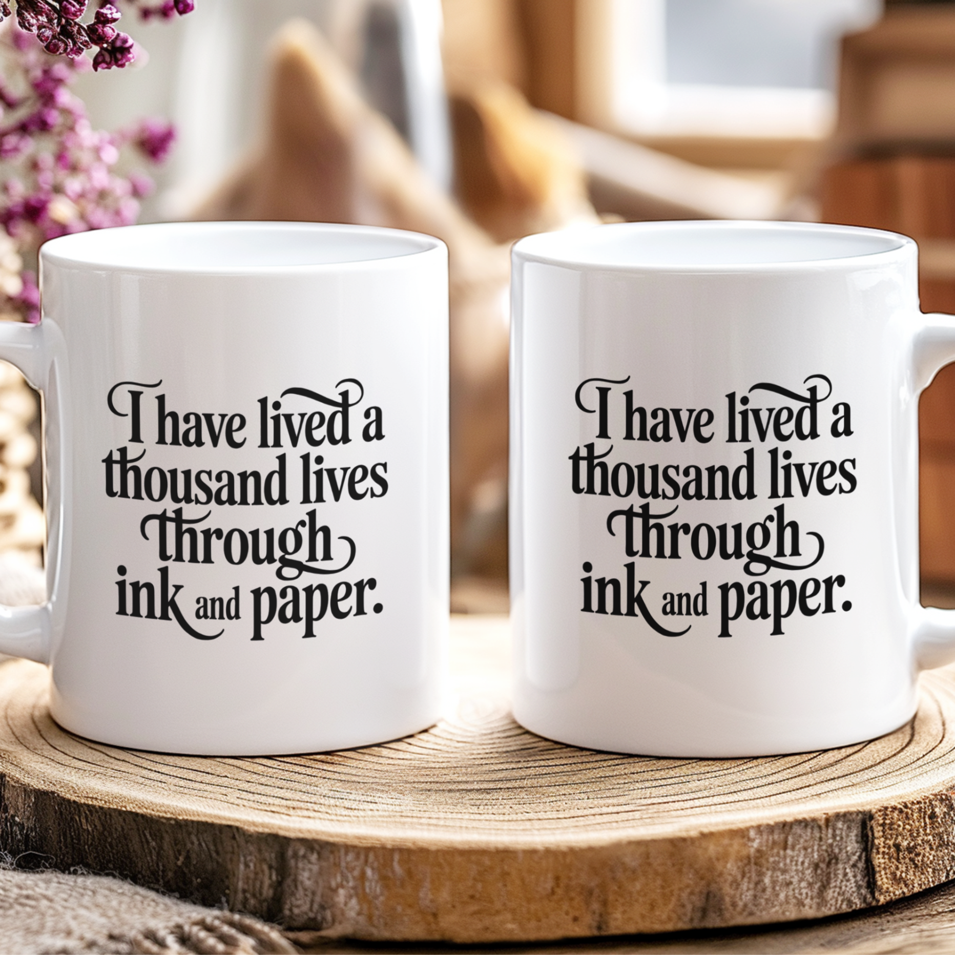Two white mugs with a quote on a wooden surface with a blurred background