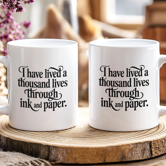 Two white mugs with a quote on a wooden surface with a blurred background