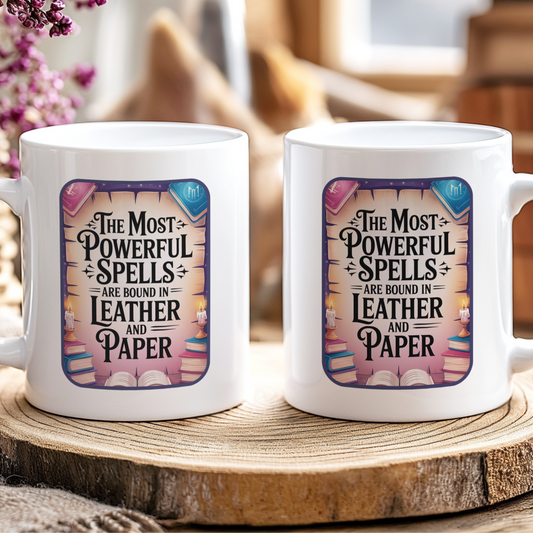 Two white mugs with a decorative design and text on a wooden surface.