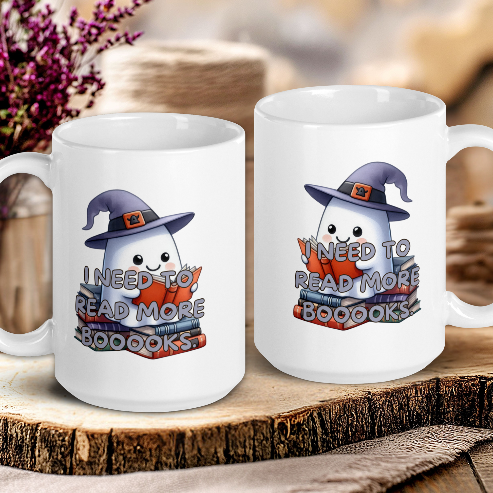 Two white mugs with ghost illustrations and text on a wooden surface.