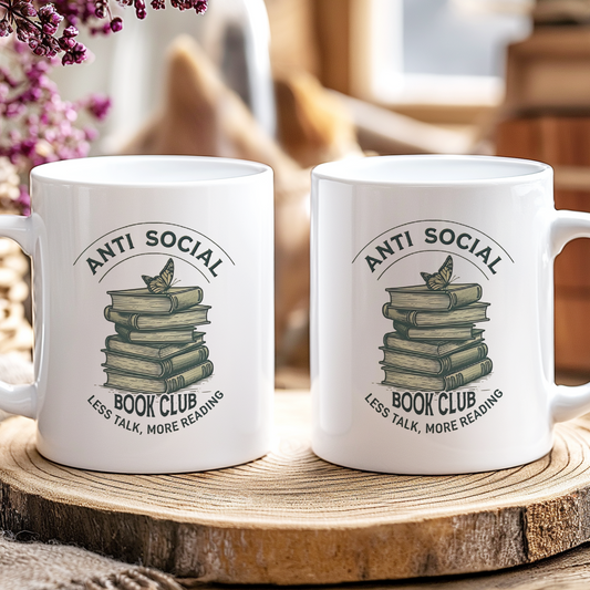 Two white mugs with 'Anti Social Book Club' design on a wooden coaster.