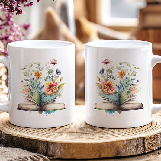 Two white mugs with floral designs on a wooden coaster, surrounded by flowers and jars.