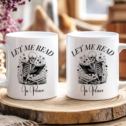 Two white mugs with skeleton designs and text on a wooden coaster.