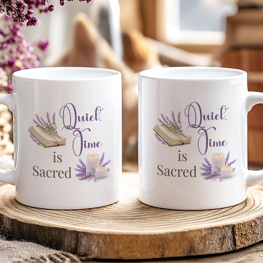 Two white mugs with 'Quiet Time is Sacred' text on a wooden coaster.