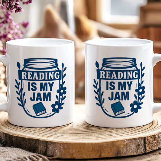 Two white mugs with 'Reading is my Jam' design on a wooden coaster.