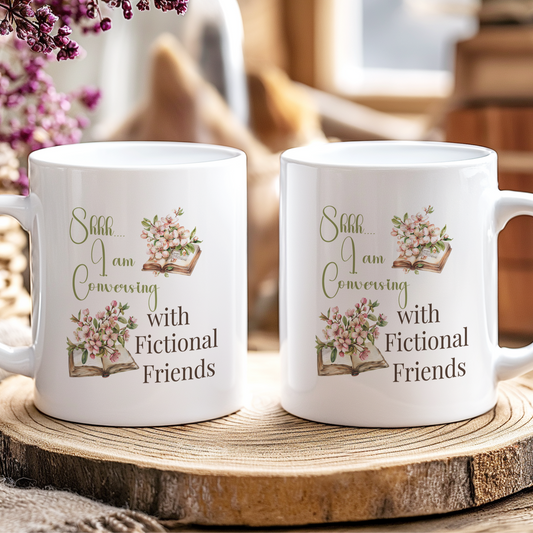 Two white mugs with floral designs and text on a wooden coaster.