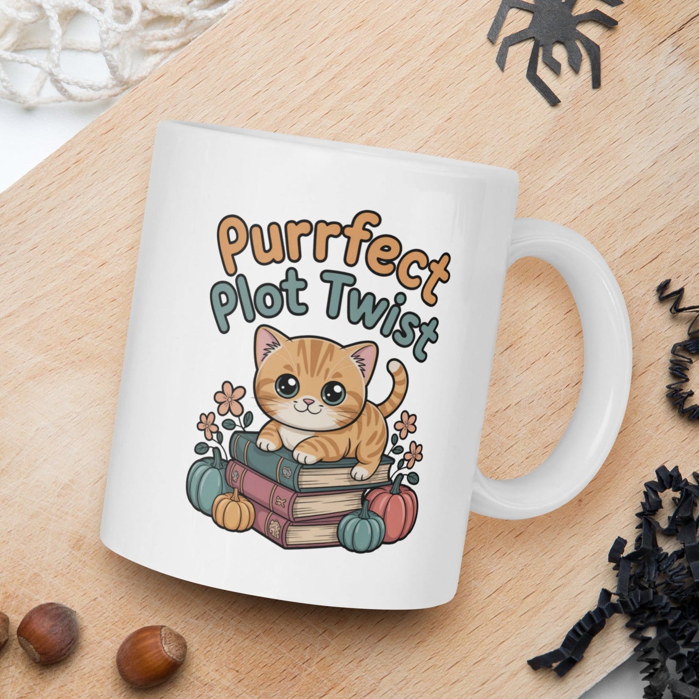 White mug with a cat illustration and 'Purrfect Plot Twist' text on a wooden board with autumn elements.