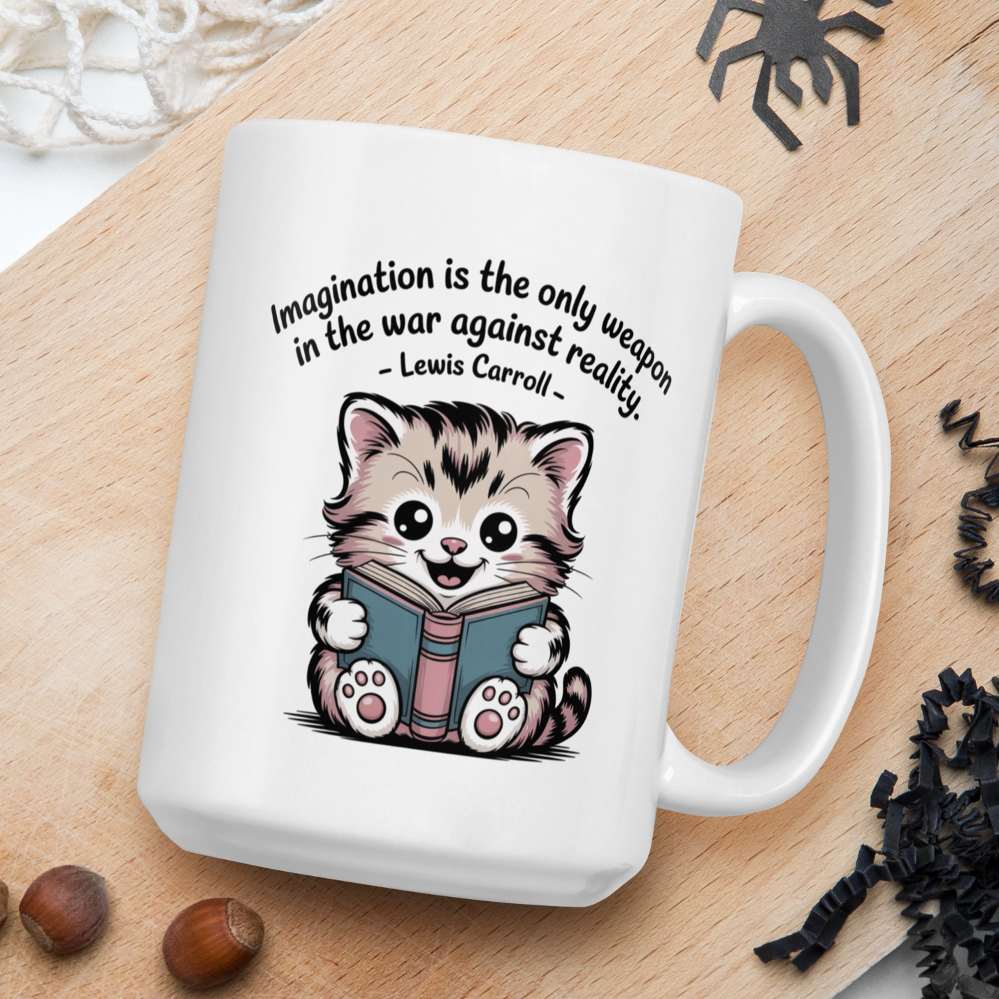 White mug with a cartoon kitten and quote on a wooden board with nuts and spider decorations.