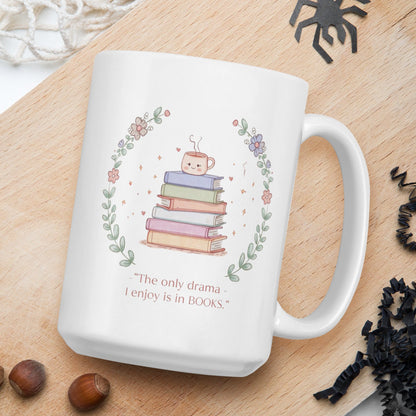 White mug with book-themed design and text on a wooden board with nuts and spider decorations.